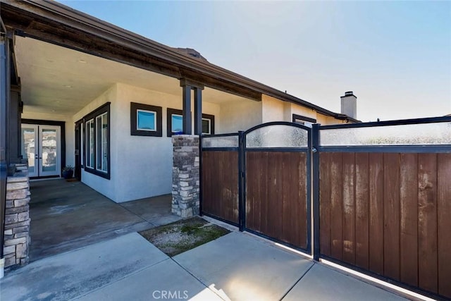 view of patio / terrace with a gate, french doors, and fence