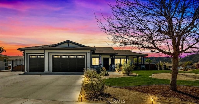 view of front facade featuring a yard, concrete driveway, and an attached garage