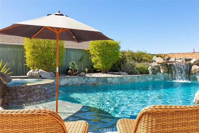 view of swimming pool with a pool with connected hot tub and a fenced backyard