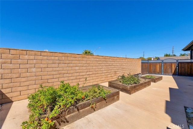 view of patio featuring a fenced backyard and a garden