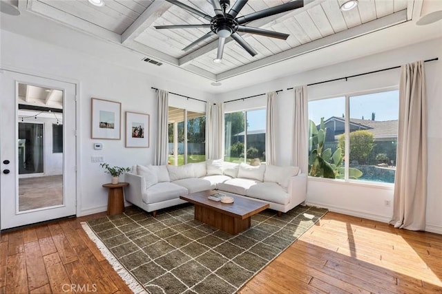 unfurnished living room with visible vents, a ceiling fan, dark wood finished floors, wooden ceiling, and baseboards