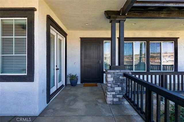 property entrance with stucco siding and stone siding