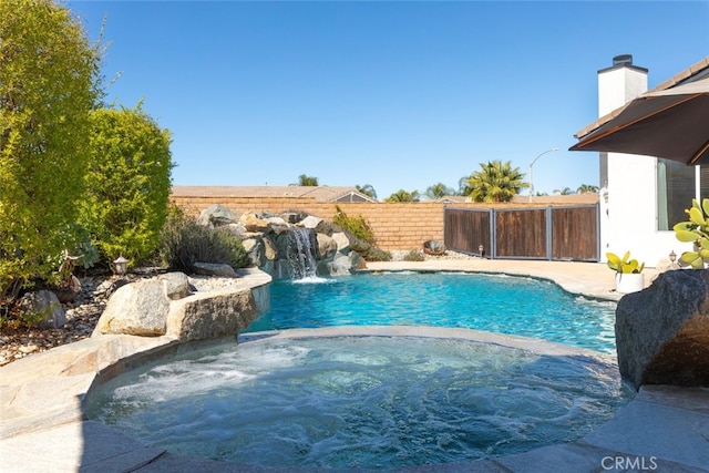 view of swimming pool featuring an in ground hot tub, fence, and a fenced in pool