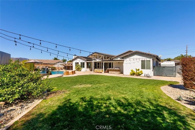 rear view of property with a patio area, stucco siding, a lawn, and fence