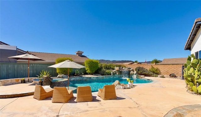 view of pool featuring a patio area, a fenced backyard, and a pool with connected hot tub