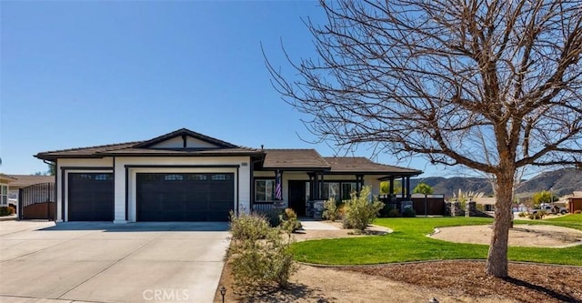 view of front of home featuring a mountain view, an attached garage, driveway, and a front lawn