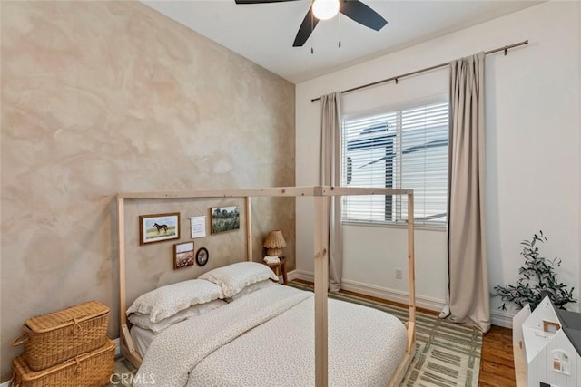 bedroom with ceiling fan, baseboards, and wood finished floors