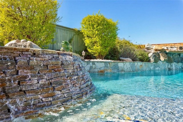 outdoor pool featuring fence