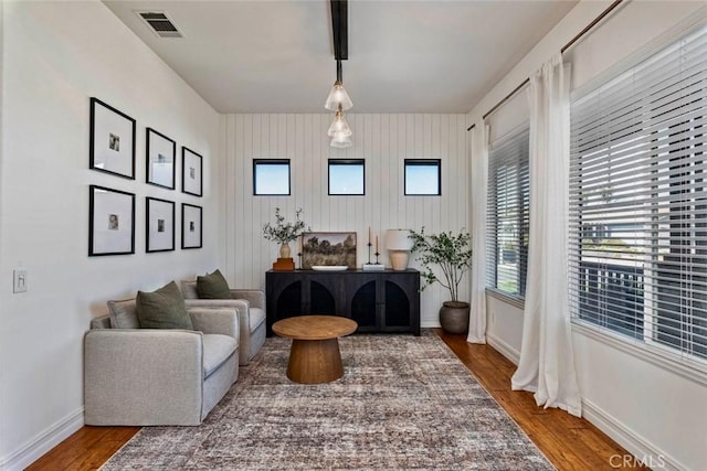 living area featuring visible vents, baseboards, and wood finished floors