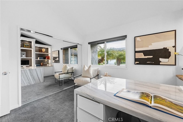 home office featuring lofted ceiling and dark colored carpet