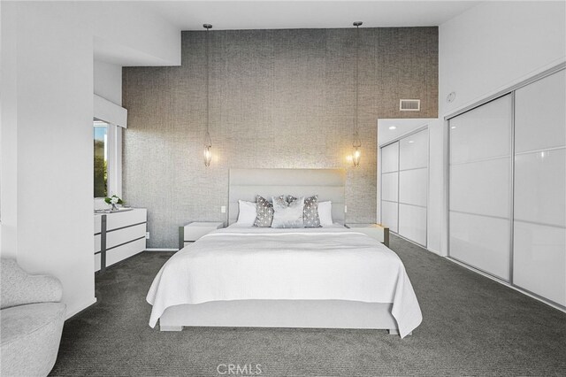 carpeted bedroom with visible vents and a high ceiling