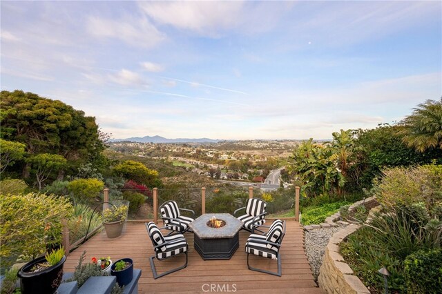 deck featuring a mountain view and an outdoor fire pit