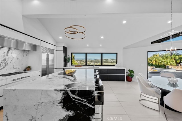 kitchen featuring decorative backsplash, built in refrigerator, an inviting chandelier, and modern cabinets