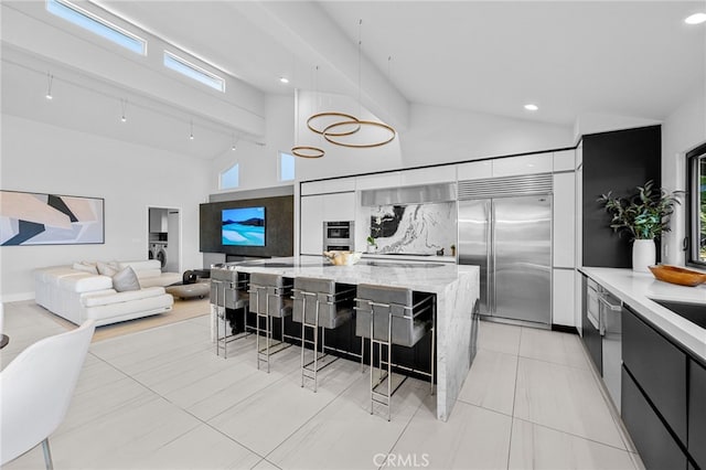 32252 Azores Rd, Dana Point, CA 92629 - kitchen with hanging light fixtures, modern cabinets, a spacious island, built in fridge, and a breakfast bar