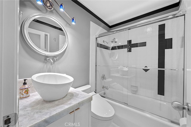 bathroom featuring vanity, toilet, and bath / shower combo with glass door