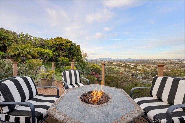 view of patio / terrace with a mountain view and a fire pit