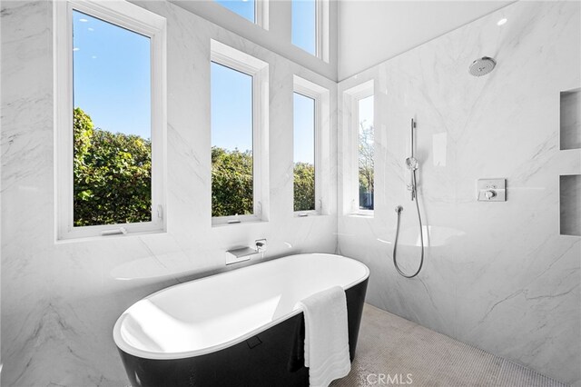 full bath featuring a marble finish shower, a healthy amount of sunlight, and a freestanding bath