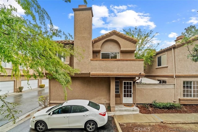 view of front of home featuring fence, a chimney, and stucco siding