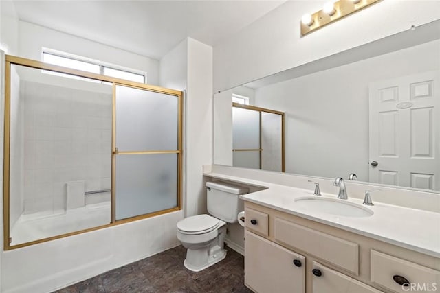 full bath with vanity, toilet, and shower / bath combination with glass door