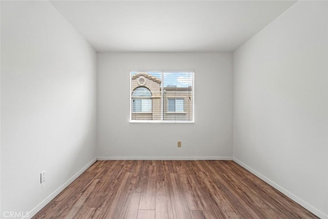 unfurnished room with baseboards and wood finished floors