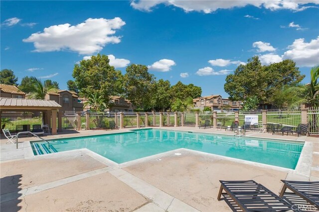 community pool featuring a patio area and fence