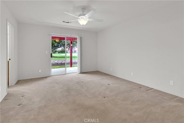 empty room featuring ceiling fan, visible vents, and light carpet