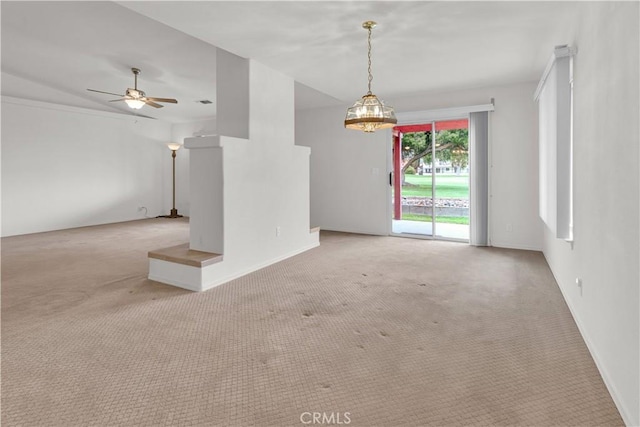 interior space with baseboards, carpet flooring, and ceiling fan with notable chandelier