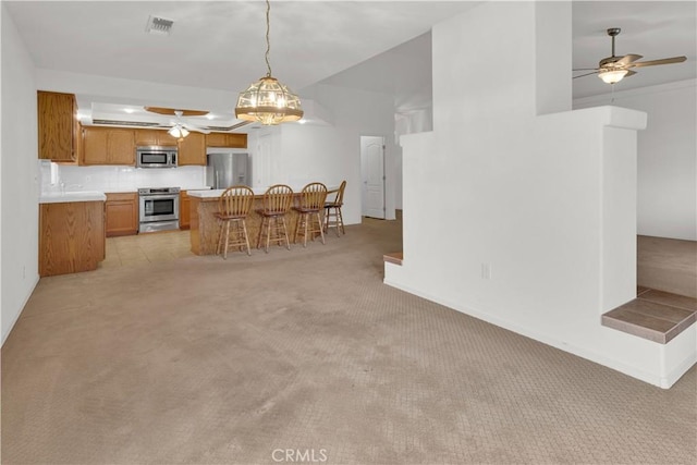 dining area with a ceiling fan, baseboards, light colored carpet, and visible vents