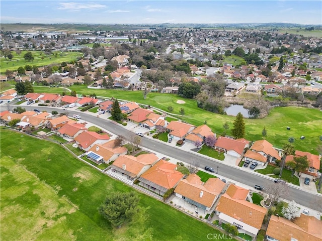 aerial view featuring view of golf course, a residential view, and a water view