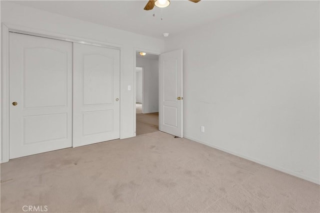 unfurnished bedroom with carpet flooring, a closet, and ceiling fan
