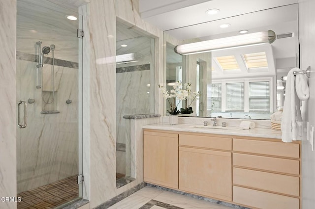 bathroom featuring a marble finish shower and vanity