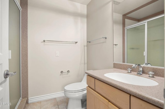 bathroom featuring vanity, baseboards, a stall shower, tile patterned floors, and toilet