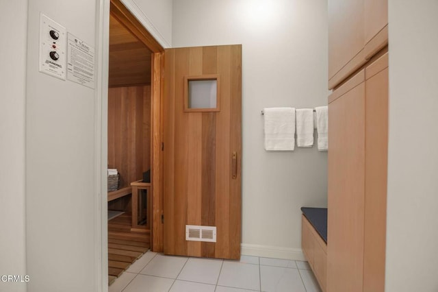 interior space featuring light tile patterned floors, baseboards, visible vents, and a sauna