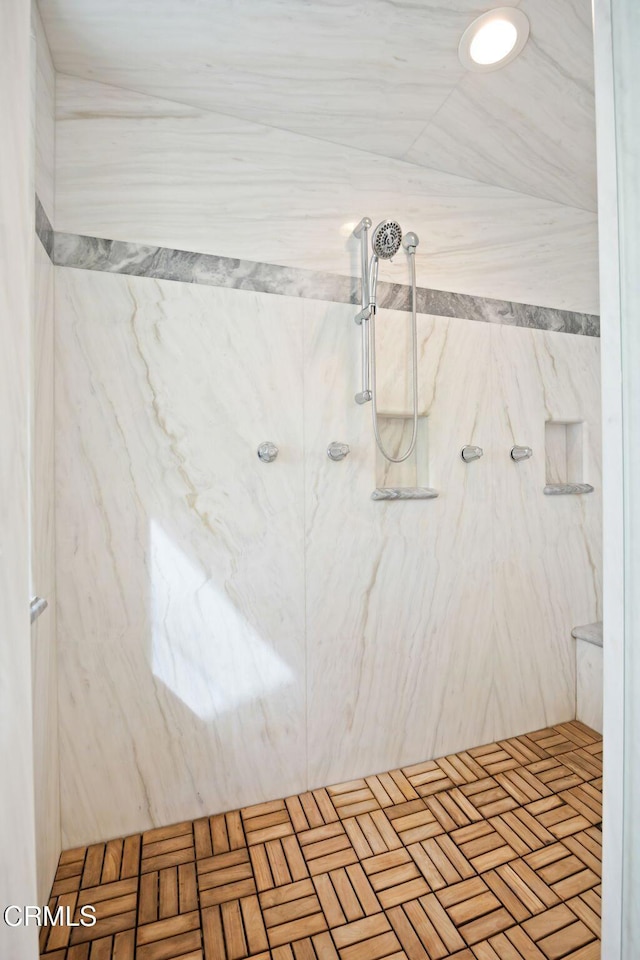 bathroom featuring a marble finish shower