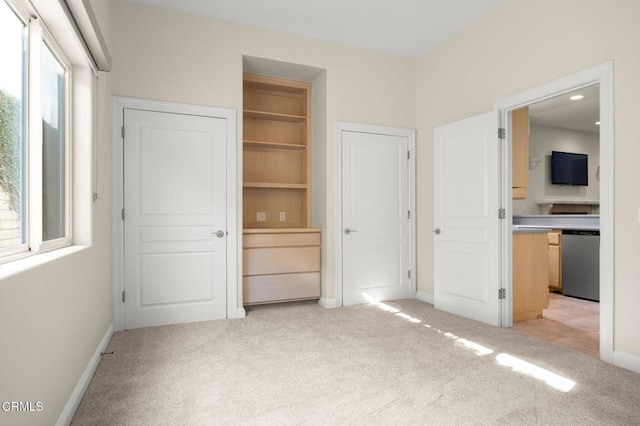 unfurnished bedroom with light carpet, multiple windows, a closet, and baseboards