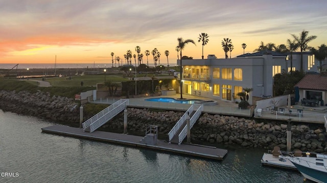 exterior space with a patio, an outdoor pool, and a water view