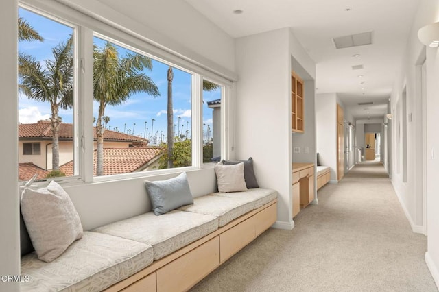 sitting room featuring light carpet and baseboards