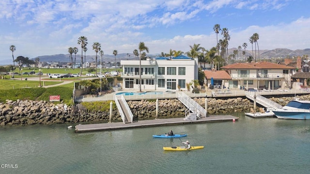 exterior space featuring an outdoor pool, a water and mountain view, and a patio