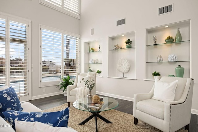 sitting room with visible vents, a healthy amount of sunlight, and wood finished floors