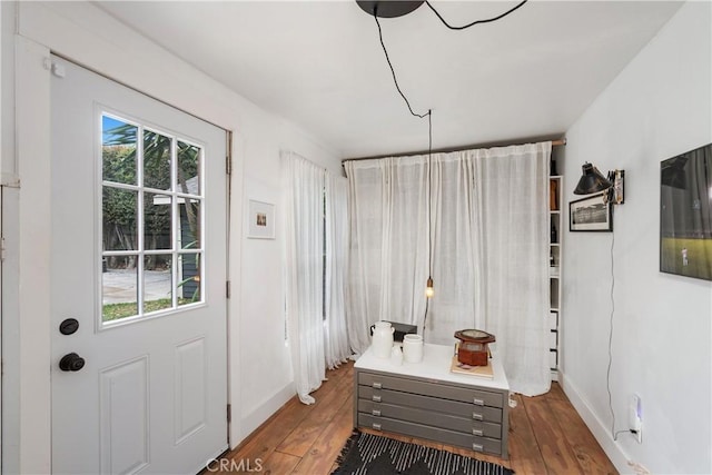 interior space with a wealth of natural light, baseboards, and wood-type flooring