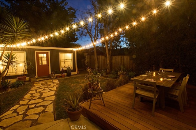 wooden terrace with outdoor dining area and fence