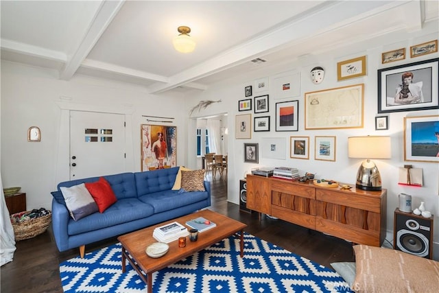 living area with visible vents, beam ceiling, and wood finished floors