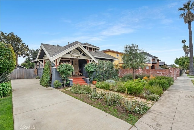 craftsman inspired home featuring covered porch and fence