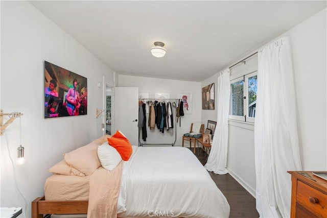 bedroom featuring baseboards and wood finished floors