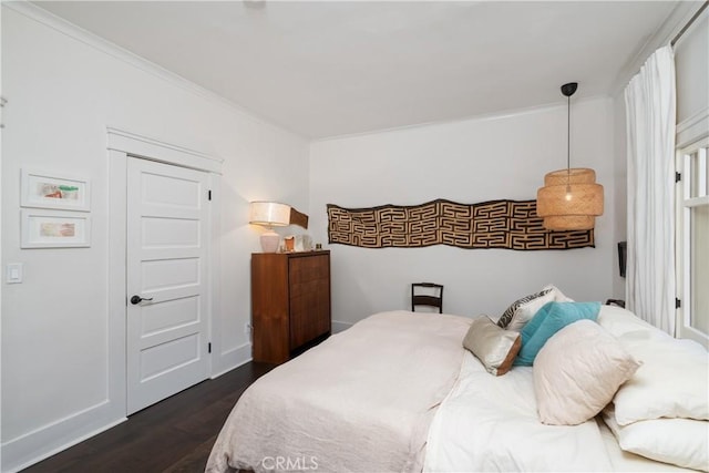 bedroom featuring baseboards and dark wood-type flooring