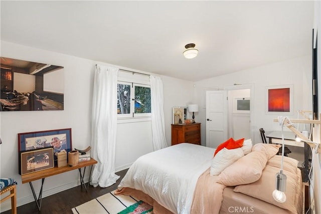 bedroom featuring baseboards and wood finished floors