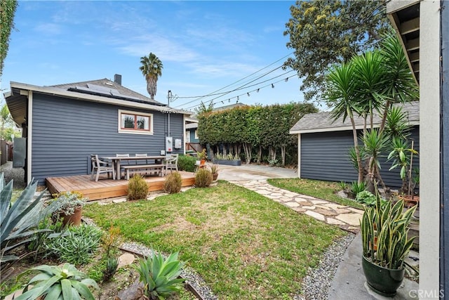 view of yard featuring a deck, an outdoor structure, and fence