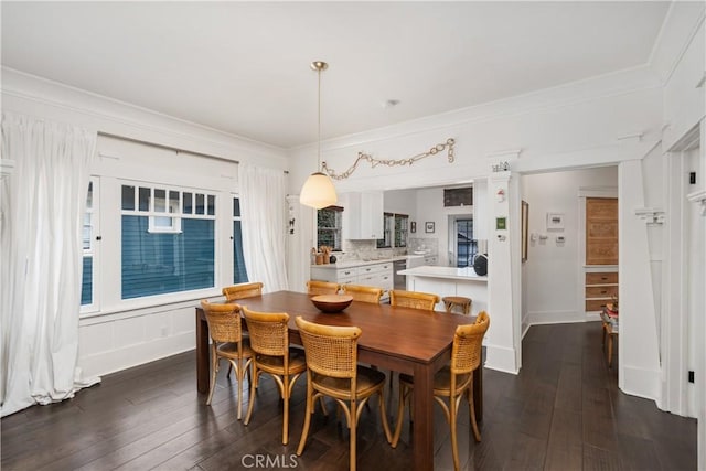 dining area featuring baseboards, dark wood-style floors, and ornamental molding