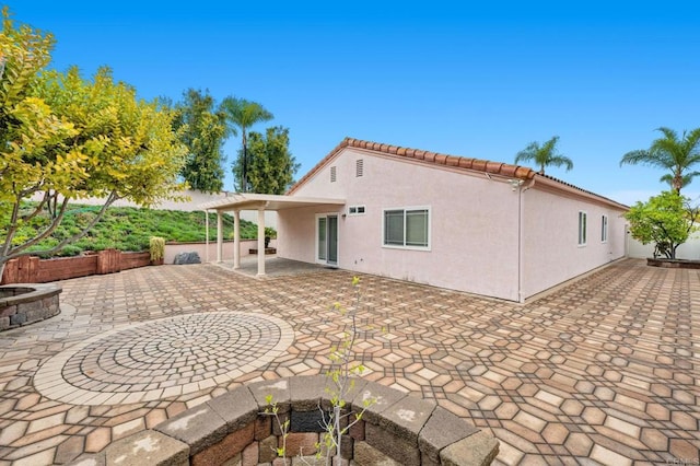 back of property with a patio area, stucco siding, a tile roof, and fence