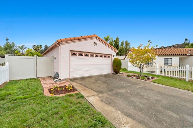 garage with a gate, concrete driveway, and fence